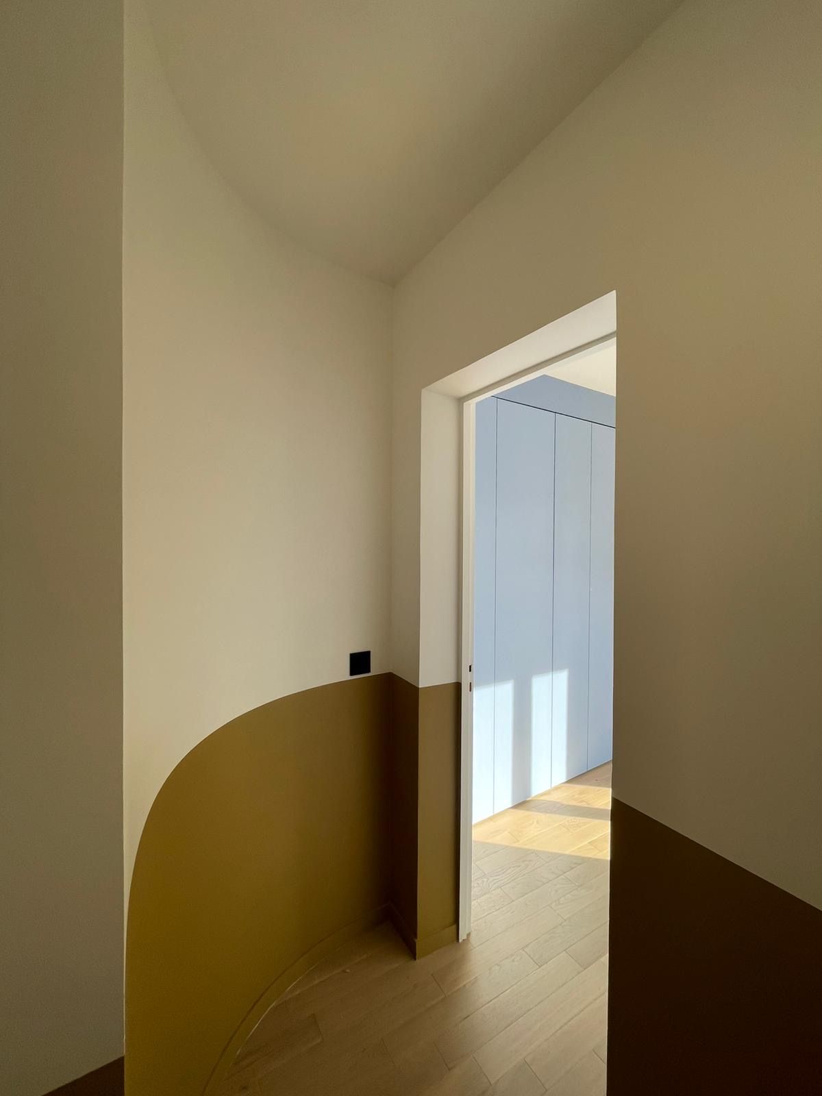 Palier : soubassement ocre dessiné en courbe le long de l’escalier